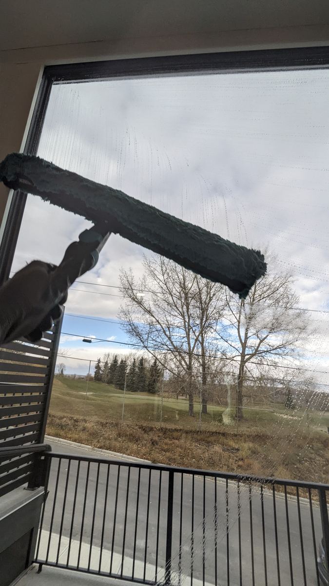 Exterior window cleaning in progress, Calgary condo balcony