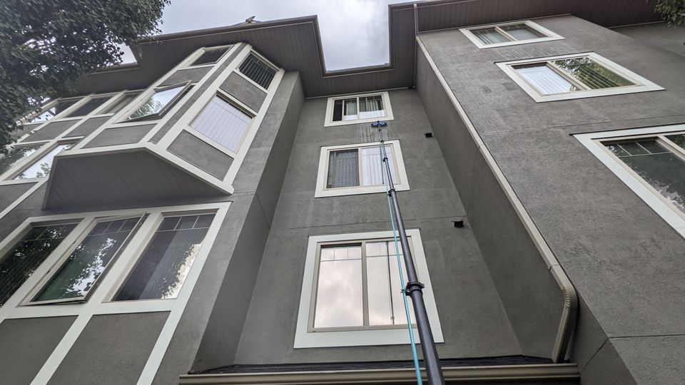 Water-fed pole reaching third-floor condo windows in Calgary
