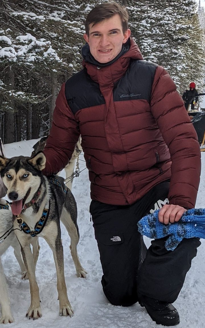 Remington Clarke, founder of Oriole Cleaning Services, with sled dogs in the Alberta Rockies