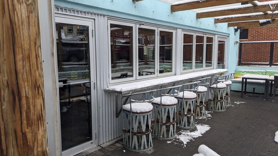 Restaurant patio folding windows cleaned in winter, Calgary